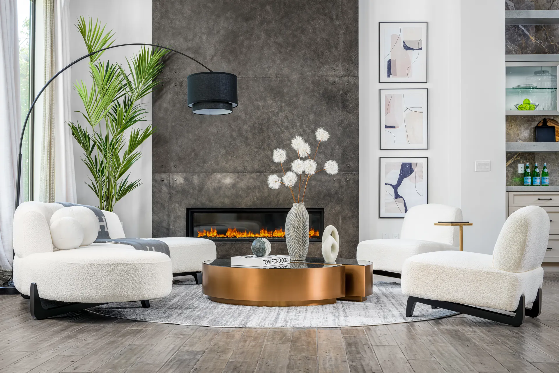 Contemporary living room staged by Stately with plush white chairs, curved gold coffee table and sculptural arc lamp